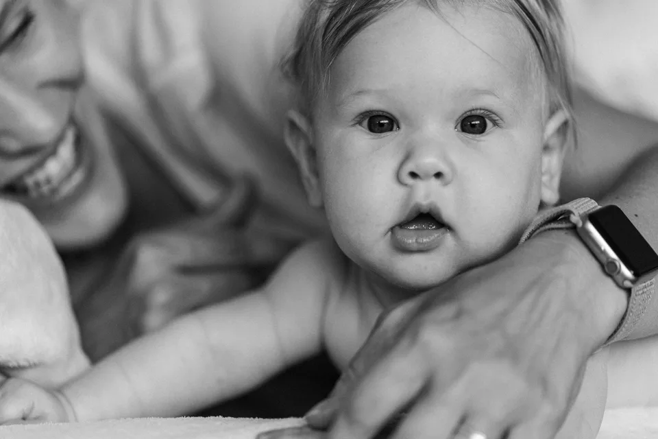 Ein Baby wird von einer Hand behutsam gestützt